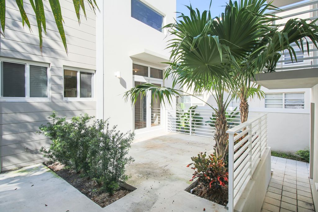 Low-rise Miami Beach condo rear patio with impact doors and windows